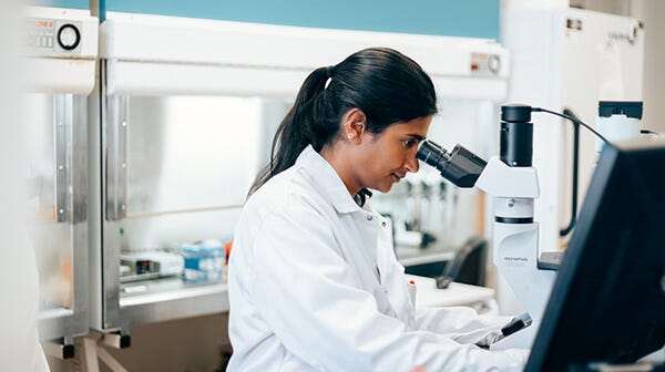 scientist using a microscope