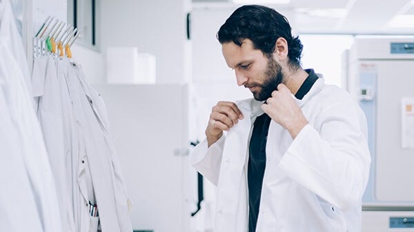 Scientist putting on a lab coat